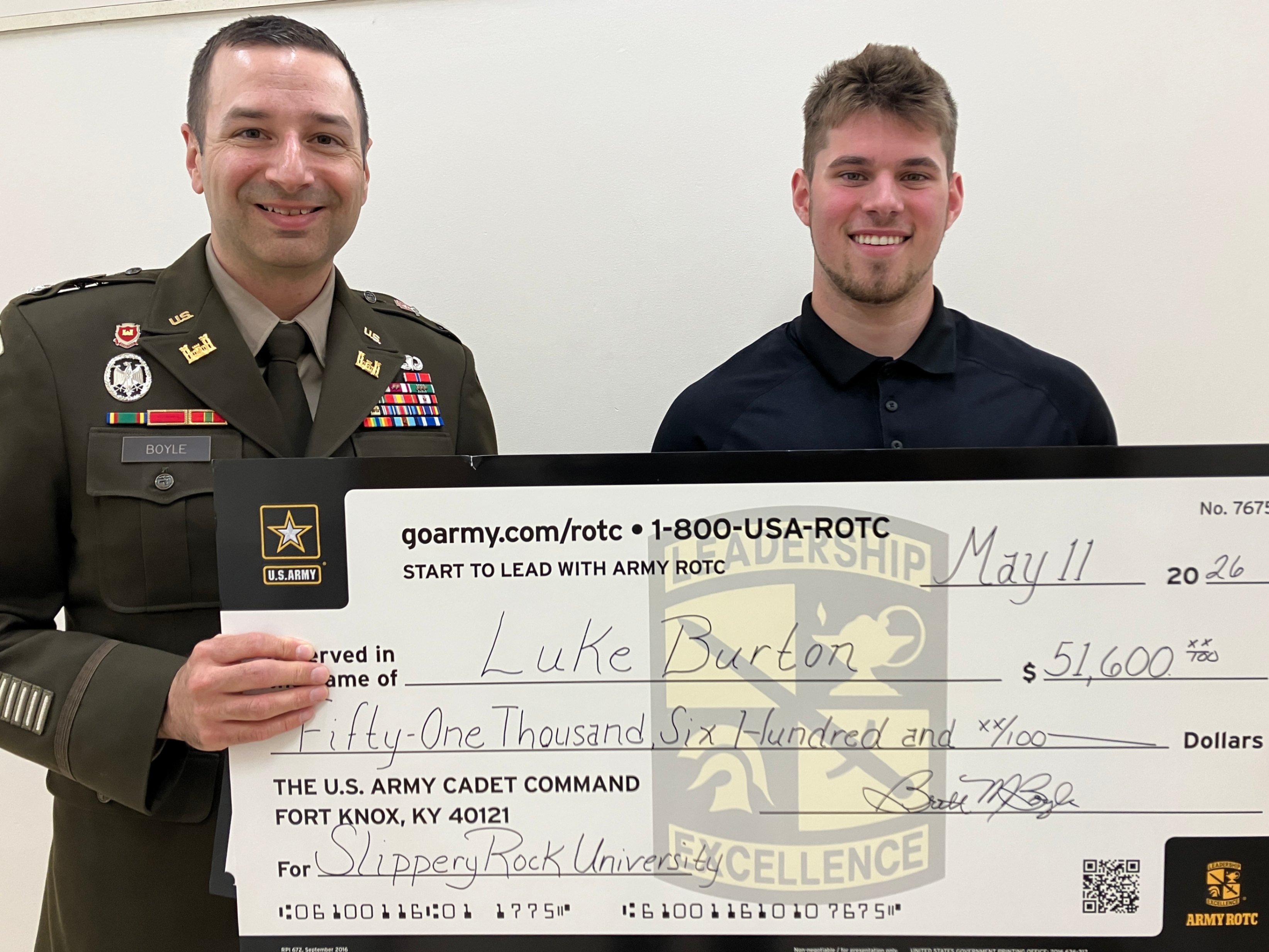 Lieutenant Colonel Brett Boyle and Luke Burton hold an oversized check in the amount of $51,600.